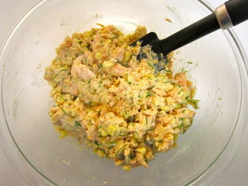 egg, chives, 1/2 of the crushed crackers, corn, mustard, mayonnaise, capers, lemon juice, and lemon zest that mix together until combined