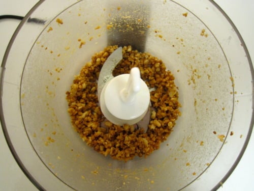 Chopped almonds ground in a food processor, prepared as an ingredient for tomato almond pesto.