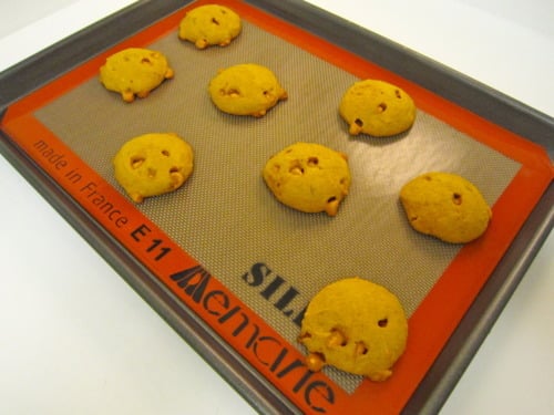 Freshly baked pumpkin butterscotch cookies on a silicone baking mat-lined baking sheet.