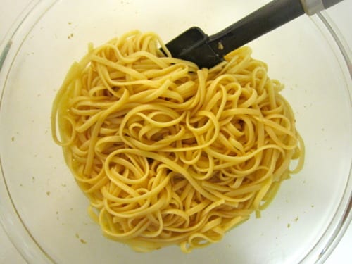 Cooked noodles in a mixing bowl being prepared for Asian chicken noodle salad.