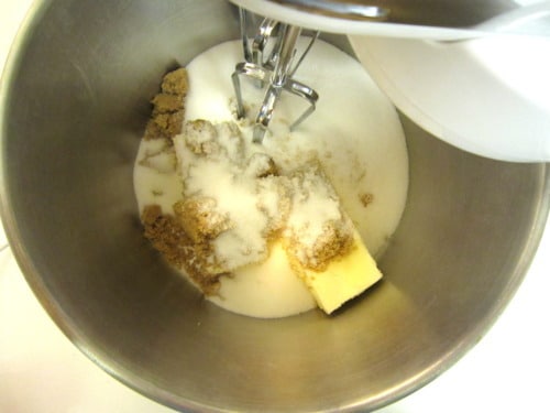 Butter, white sugar, and brown sugar in a mixing bowl with beaters ready to cream together.