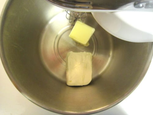 Butter and cream cheese in a stand mixer bowl, ready to be mixed for vanilla cream cheese frosting for red velvet cupcakes.
