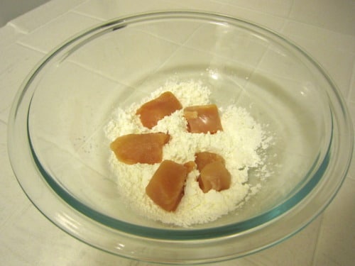 Raw chicken pieces coated in flour for General Tso's Chicken.