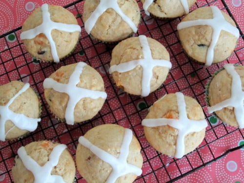 Hot cross bun muffins with icing crosses on top, cooling on a wire rack.