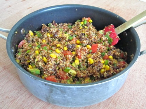 Soy chorizo quinoa salad in a pot with corn, black beans, tomatoes, and green onions.