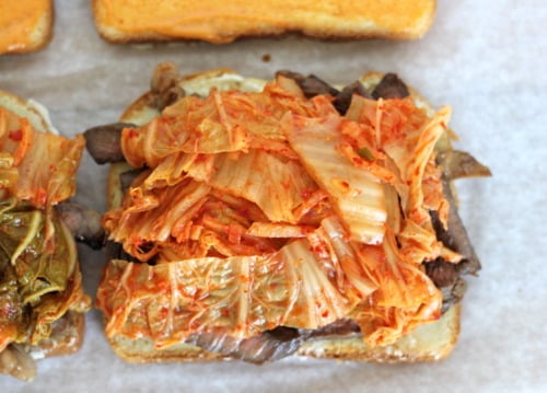 Korean fusion sandwich with grilled beef, kimchi, and a spread on toasted bread.