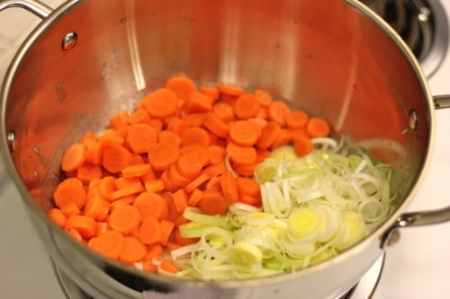Sliced carrots and leeks in a pot, being sautéed for chicken pot pie filling.