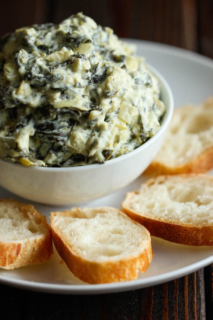 Creamy spinach and artichoke dip served with baguette slices.