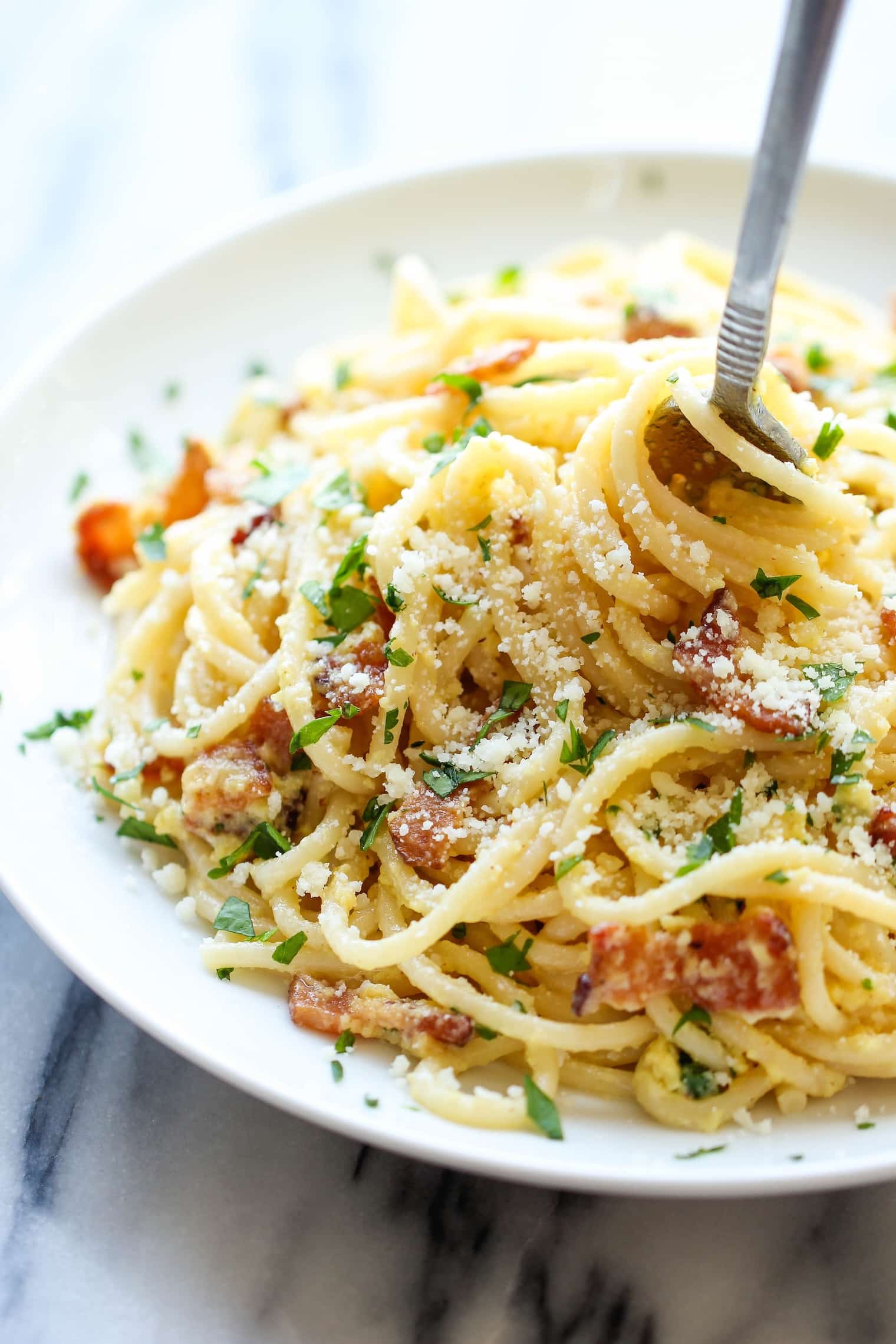 Creamy homemade spaghetti carbonara with bacon and fresh parsley