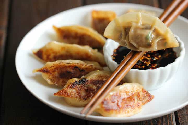 Golden and crisp-cooked potstickers served with soy sauce.