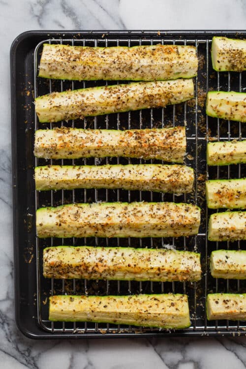 Baked Parmesan zucchini spears on a baking rack