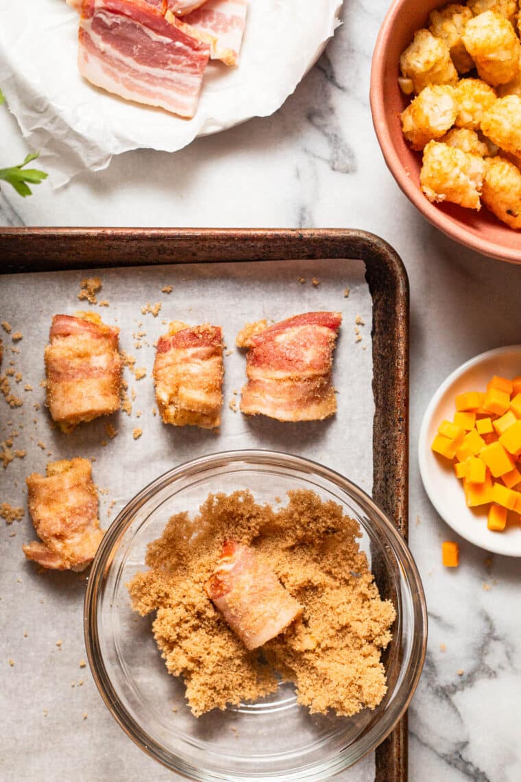 Coating bacon wrapped tater tots in brown sugar before baking