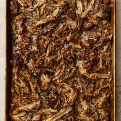 Crispy slow cooker pork carnitas shredded on a baking sheet