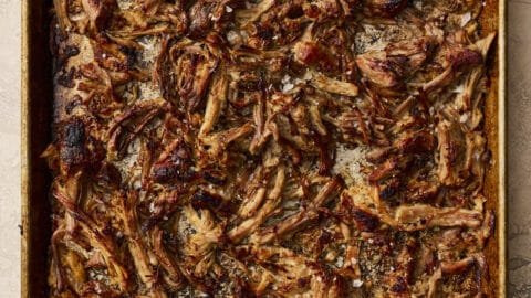 Crispy slow cooker pork carnitas shredded on a baking sheet