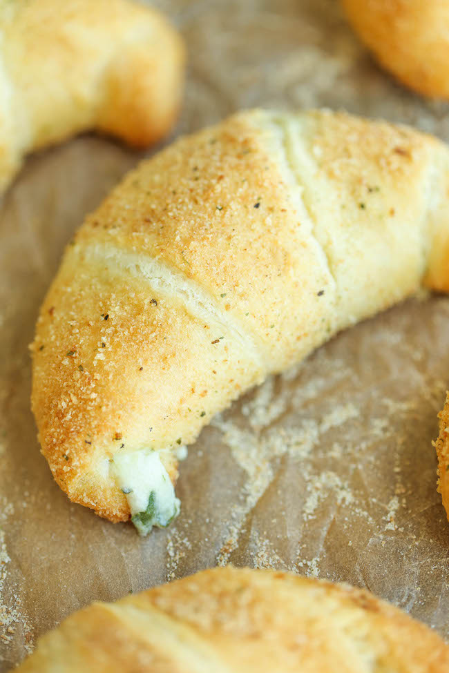 Spinach and Artichoke Dip Roll Ups - Everyone's favorite dip is stuffed into a flaky, buttery crescent roll, oozing with all that melted cheesy goodness!