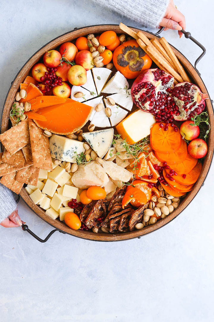 Winter Cheese Board - Your guests will be so impressed with this Winter harvest cheese board! It takes 10 minutes to prep and it has all of your favorite winter fruits, cheeses and crackers. And it serves a huge gathering without breaking the bank!