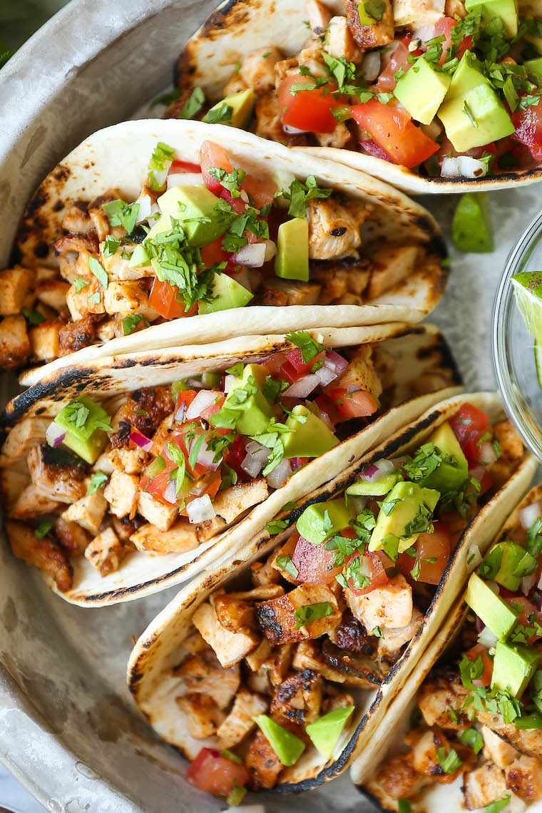 Chicken tacos recipe plated with cilantro and lime wedges