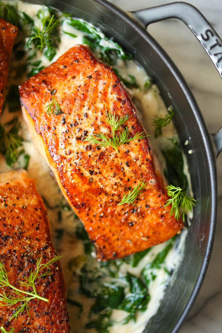 Salmon with Garlic Cream Sauce - Perfectly pan-seared salmon served with the most irresistible garlicky cream sauce with sneaked in spinach!