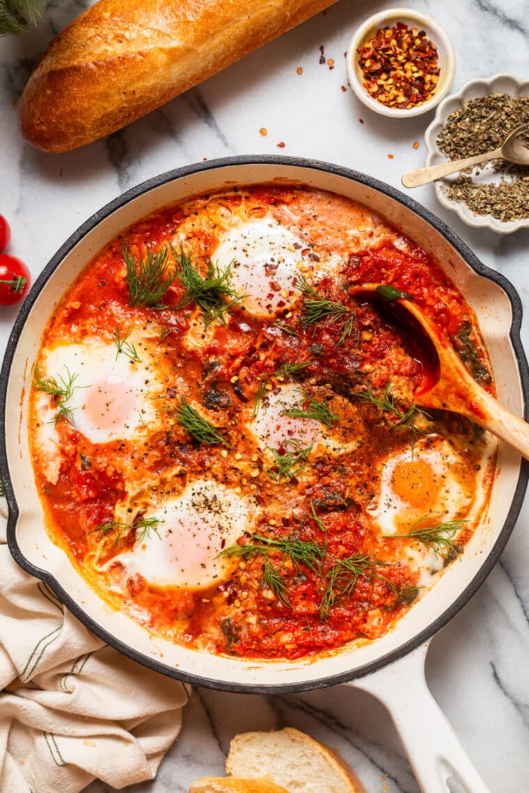 Eggs in Purgatory - An easy, rustic, one pan dish with eggs poached in a rich, savory, garlicky tomato sauce. Best served with all the crusty bread for dunking!