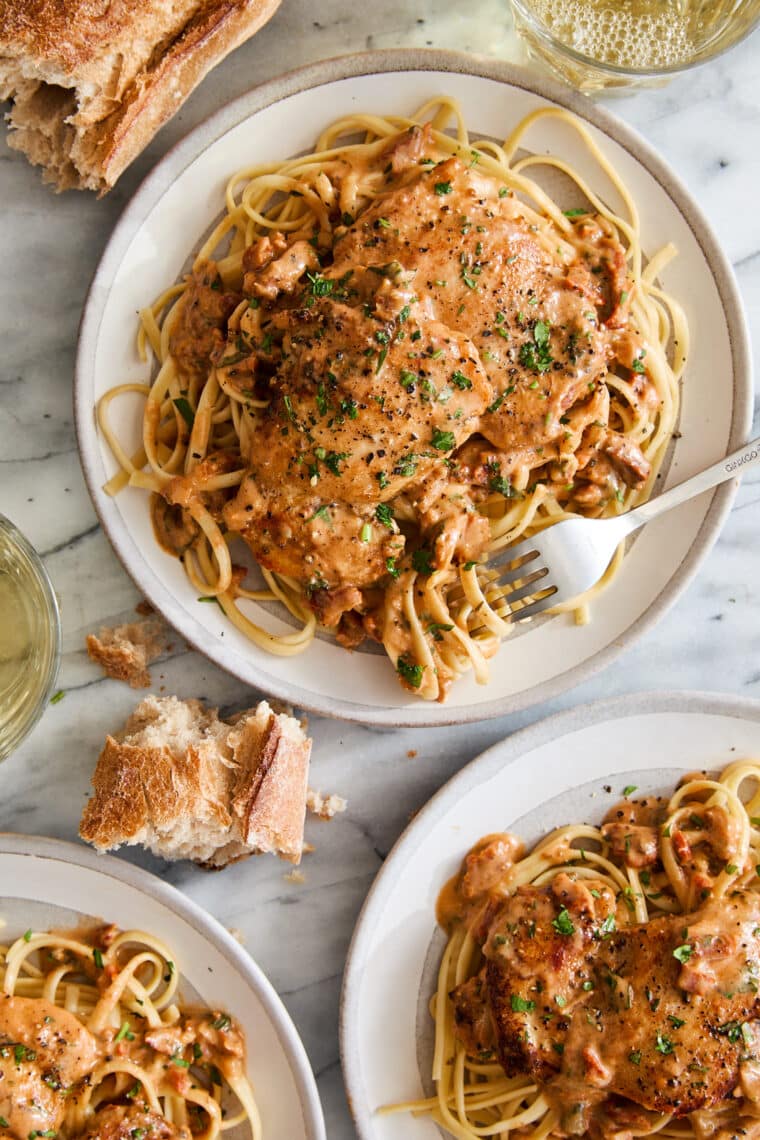 three plates of pasta with chicken and sundried tomato parmesan cream sauce